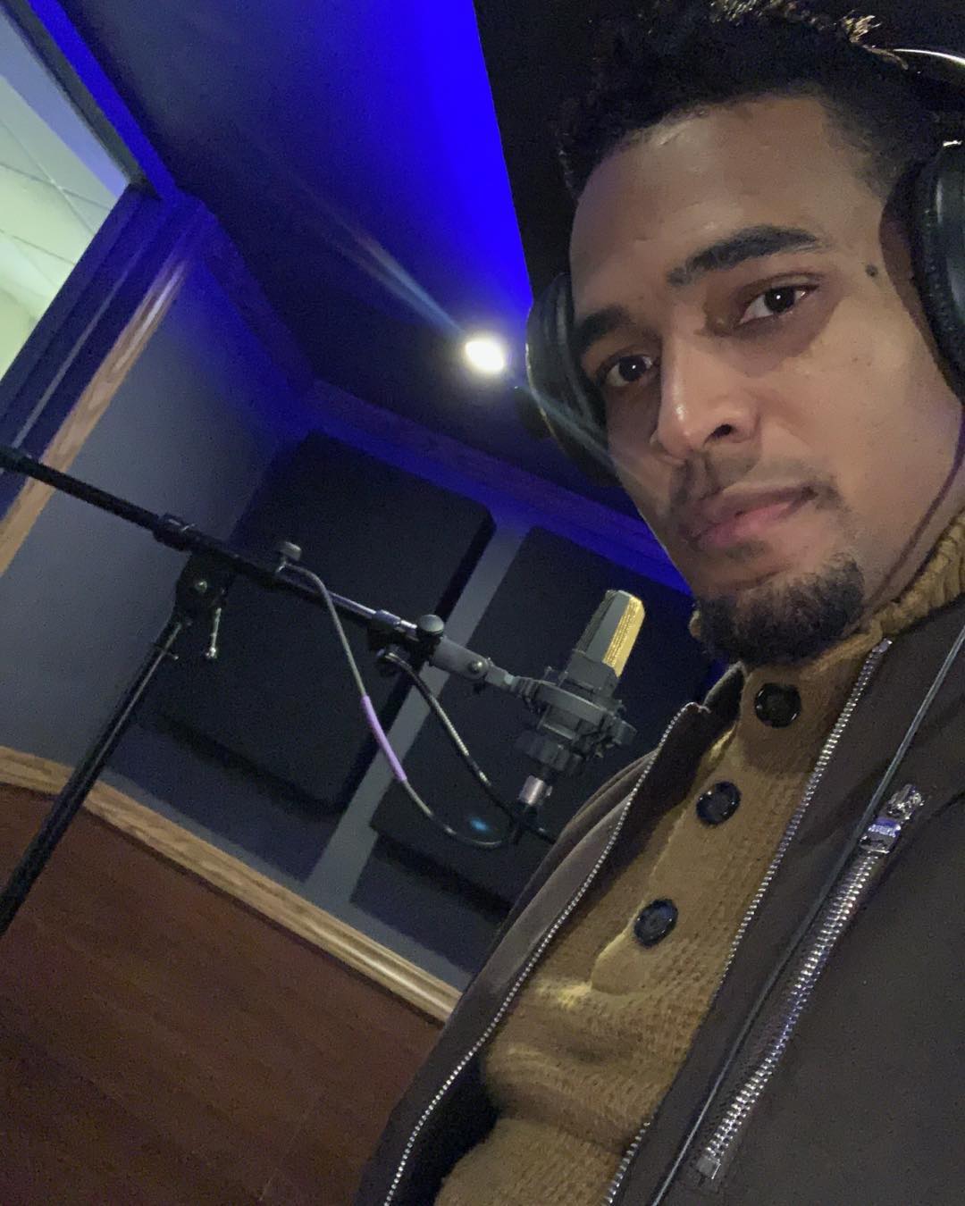 Charlie Pe con audífonos frente al micrófono en el estudio de grabación (2019)